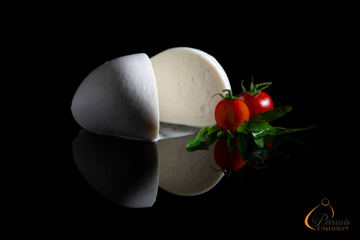 Fior di latte tagliato con pomodorini su sfondo nero